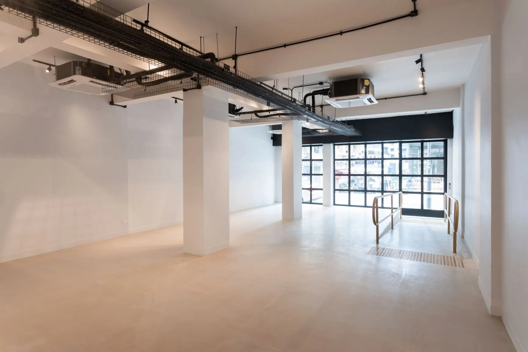Commercial space on Queen’s Road West, Sai Ying Pun, features white walls, exposed ceilings, and a ramped entrance.