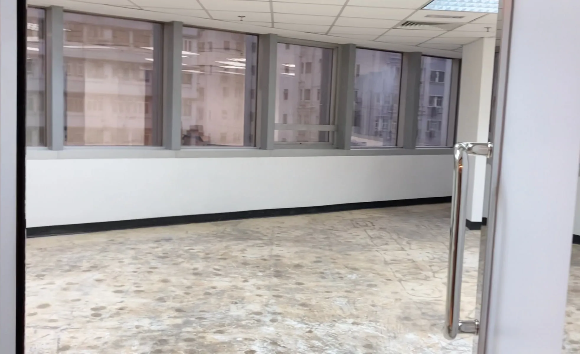 Ref#3224: Bright office or shop space with large windows, white walls, and a glass door with metal handle now available to rent. Enjoy city views from this modern space perfect for your business needs.
