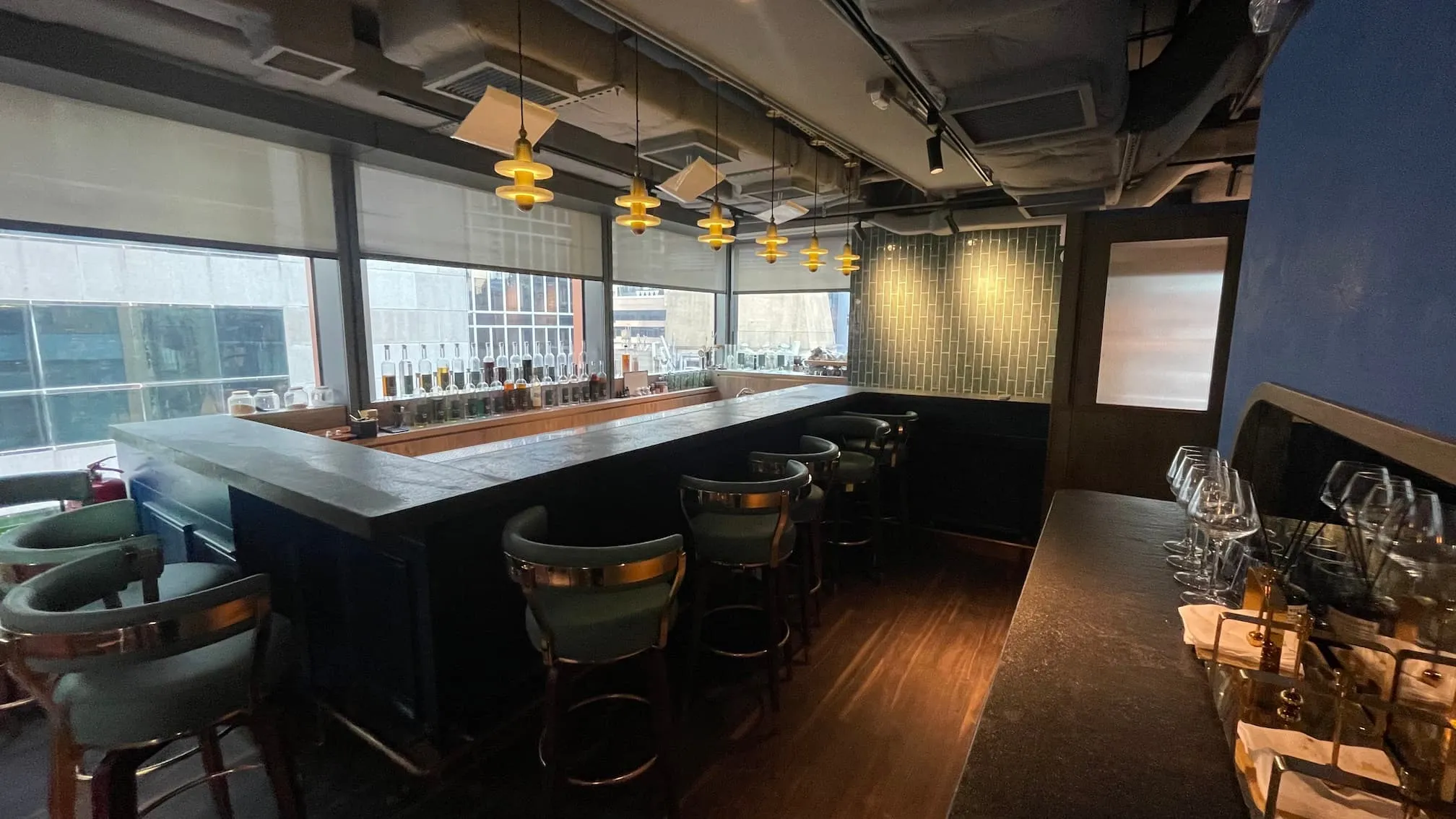 Bar on Wellington Street with high stools, pendant lights, and city views located in Central.