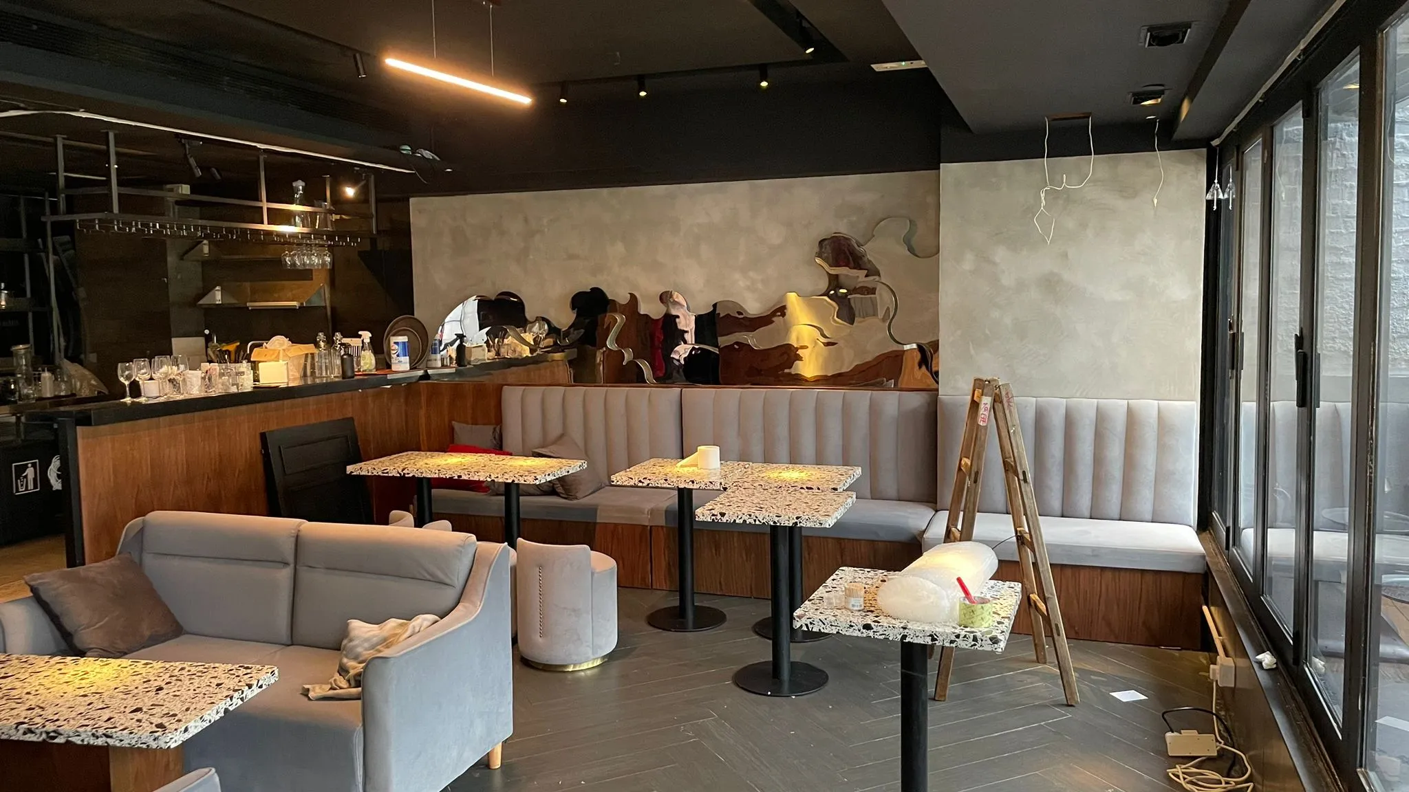 中環雲咸街一間現代咖啡店內部,設空置枱及灰色椅子,牆上有鏡,可見清潔用品。