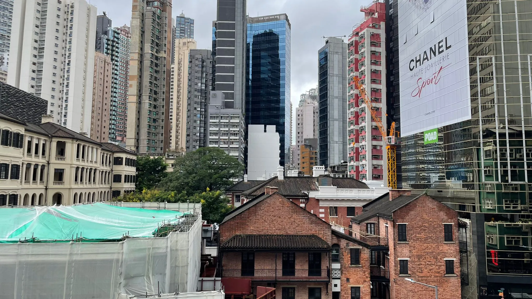 中環雲咸街,兩旁為現代高樓大廈及磚砌建築物,天空多雲。