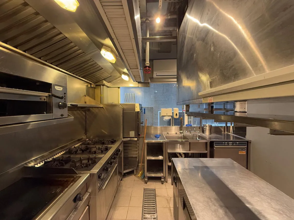 Ref#3636: Clean, well-lit commercial kitchen with stainless steel appliances—stoves, ovens, shelves, and essential equipment. Ideal space for those looking to rent a shop or restaurant.