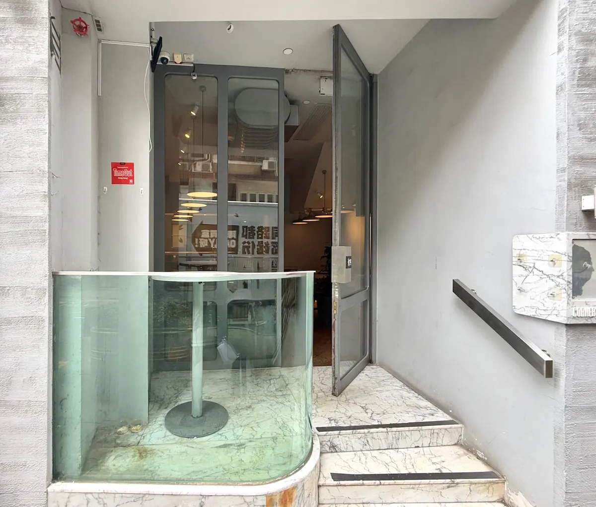 Ref#3636 features a modern entrance with an open glass door, marble-finished stairs, a left glass railing, and right handrail—ideal for renting as office or shop space. The inviting interior is visible from outside.