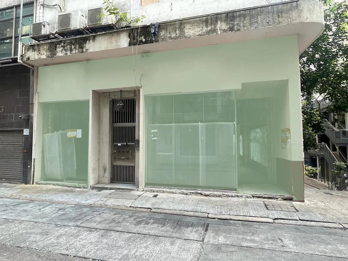 Ref#3626: Vacant storefront for rent as a shop or restaurant with large frosted glass windows, metal door, weathered exterior with peeling paint and window signage, located on a busy city street.
