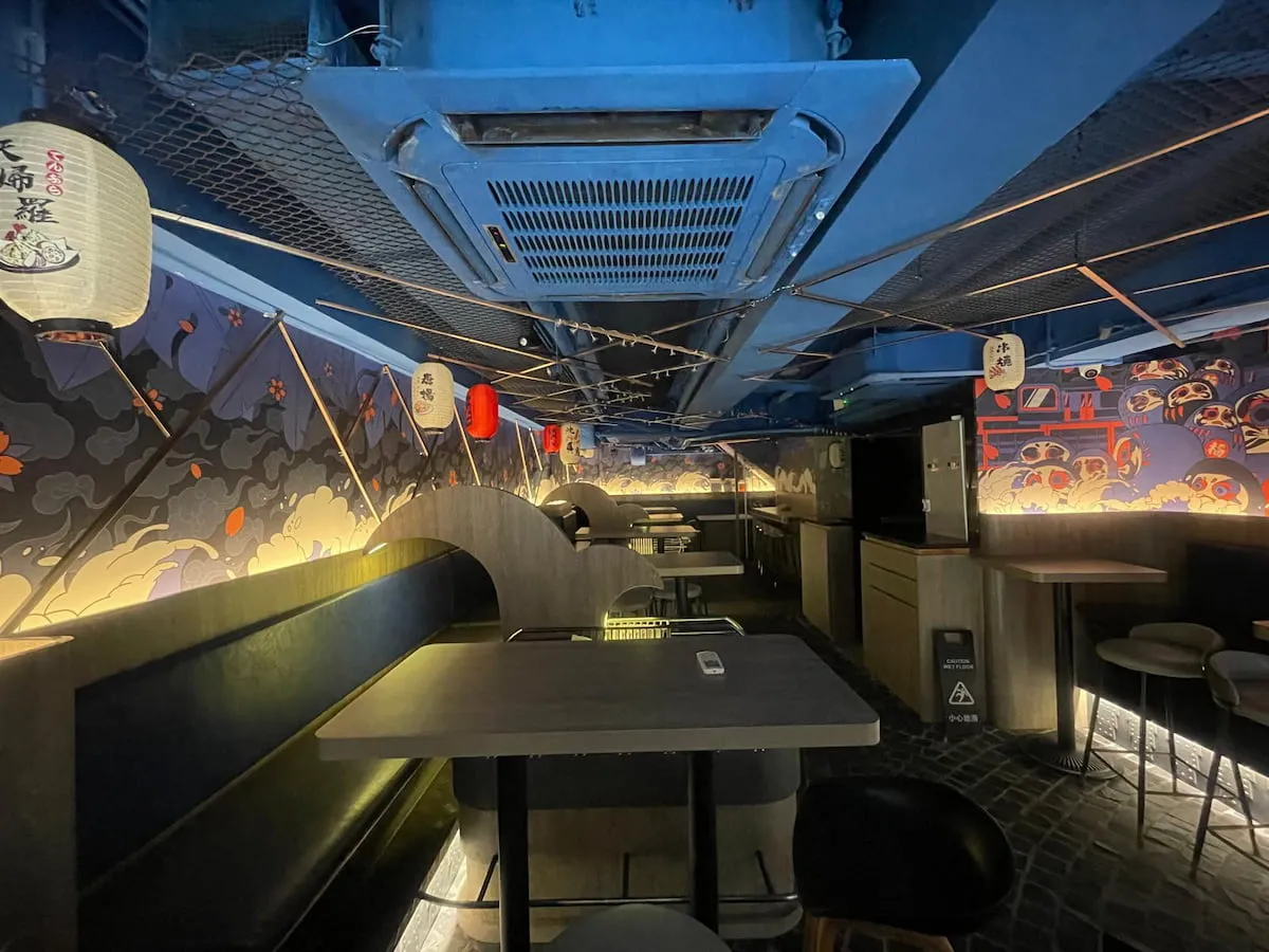 Ref#3627 offers a dimly lit modern restaurant with Japanese lanterns, wave and fish wall art, black tables and chairs, and a striking blue ceiling ventideal for anyone seeking to rent restaurant space with distinctive style.