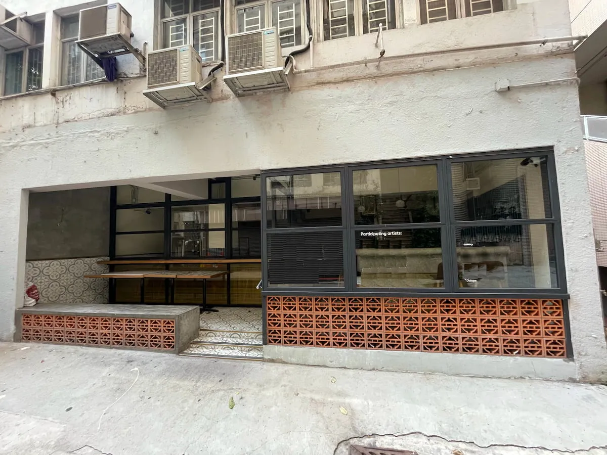 Ref#3640 is a small, modern cafe for rent featuring large open windows, wooden tables, patterned tiled walls, a red brick lattice front with bar seating, and exterior-mounted air conditioning units.