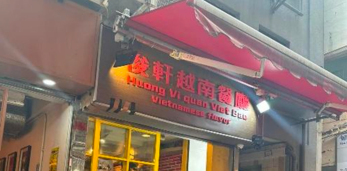 Ref#3669: A restaurant with a red awning, Chinese characters on the sign, "Huong Vi Quan Viet Eat," and Vietnamese flavor in English above a yellow-framed window—ideal for those seeking to rent a restaurant in the area.