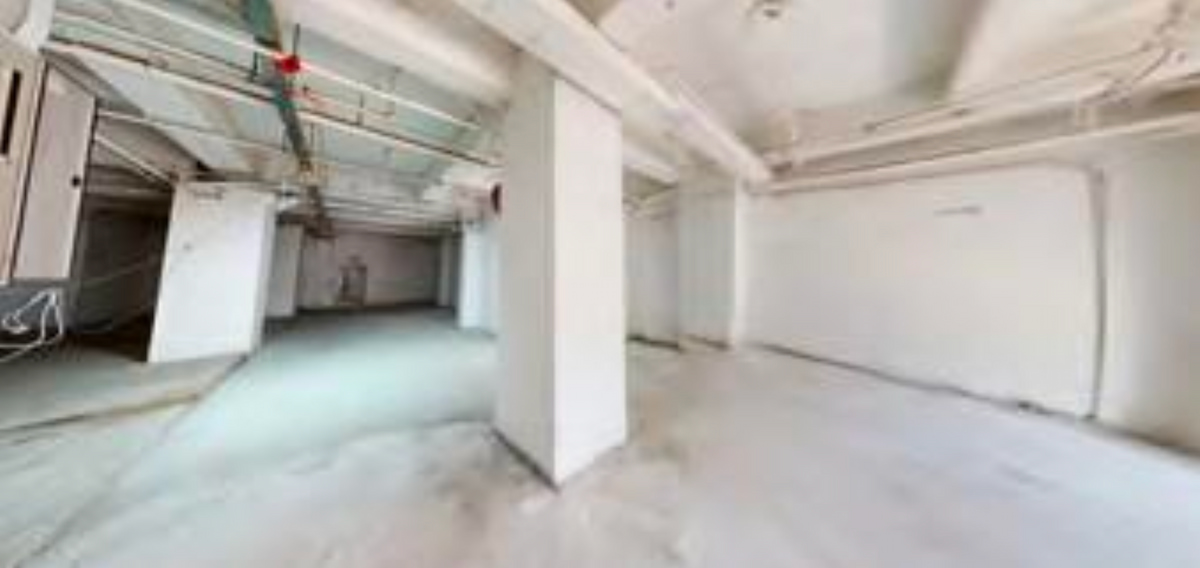 Ref#3667: Spacious, brightly lit area with white walls, exposed pipes, columns, and a concrete floor. Unfinished or under renovation60ideal for shop rental or office space in a large basement or industrial setting.