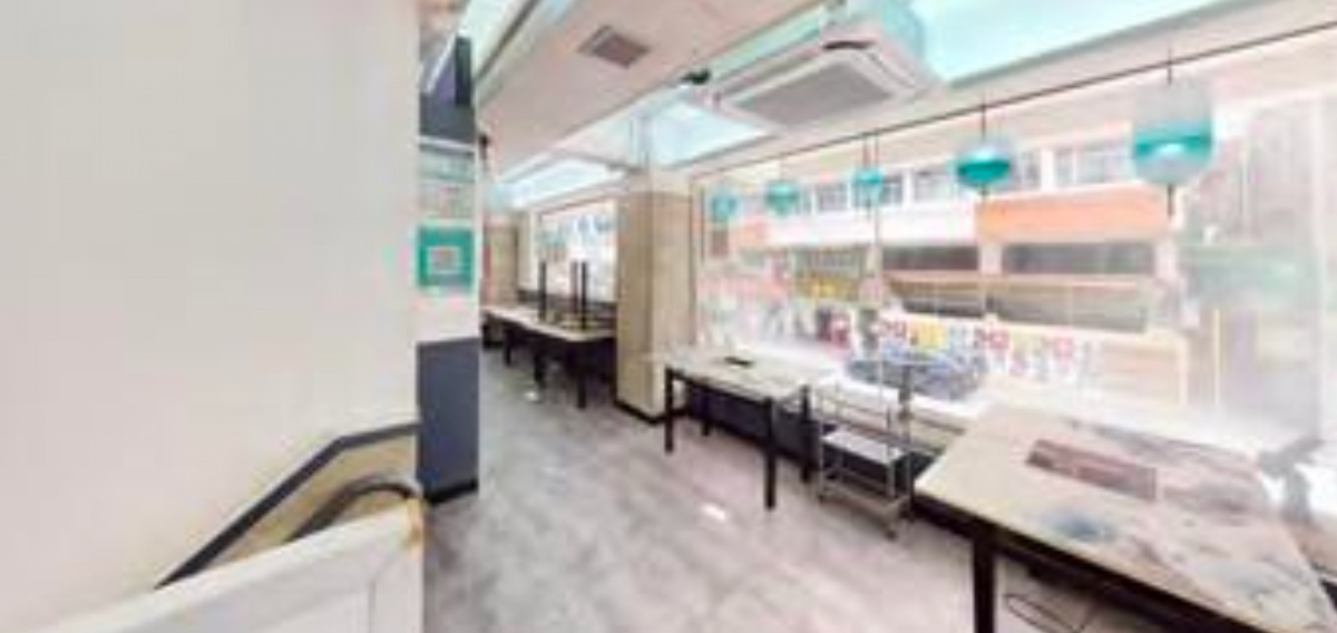 Ref#3664 features a bright, modern cafe interior with large windows, turquoise hanging lights, and neatly arranged tables by the window97ideal for those seeking to rent a restaurant. The street and buildings outside are visible.