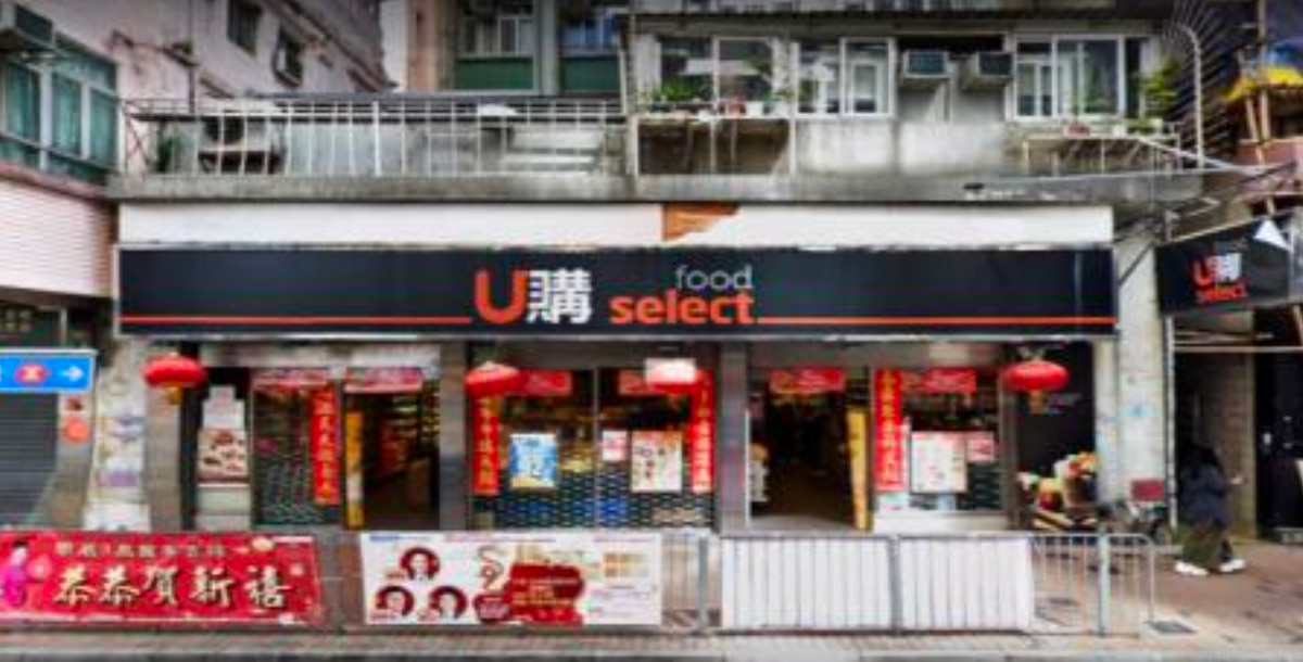 Ref#3661: Storefront labeled U Select food, decorated with red lanterns and festive banners, available for rent in a busy urban area with apartments above and metal railings in front.