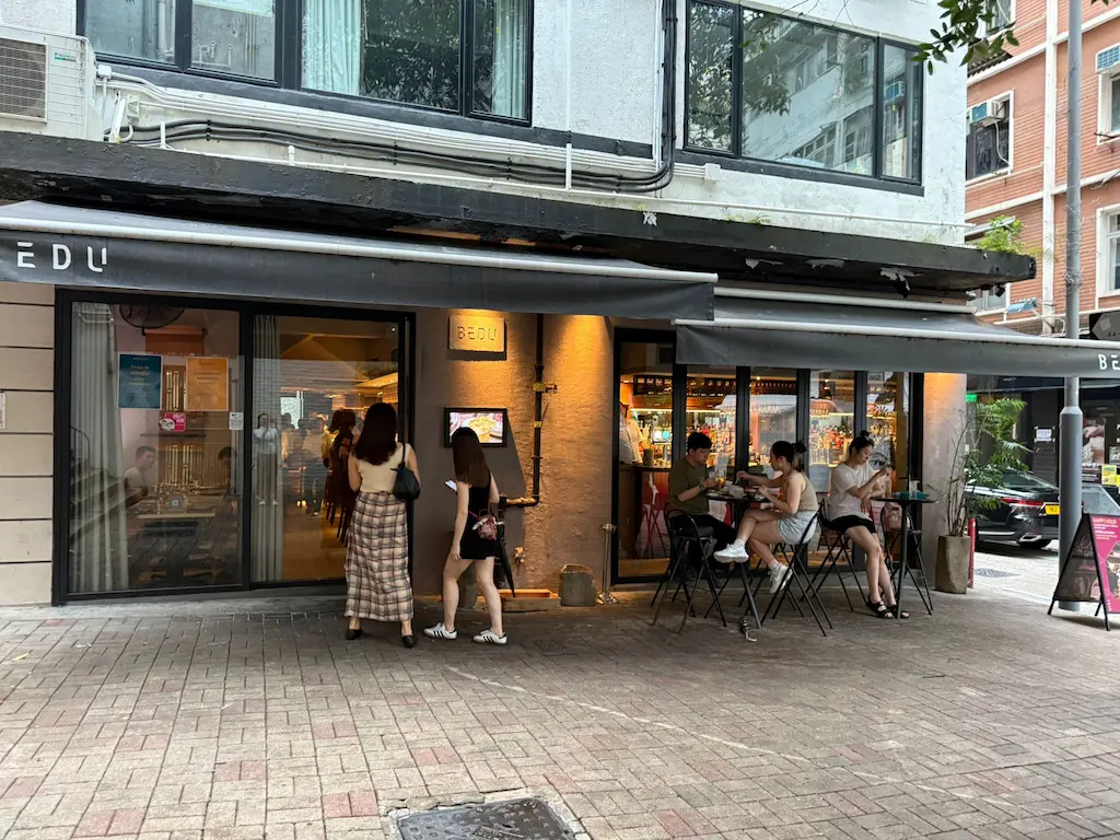 Ref#3654 offers a modern cafe9 with large windows and a black awning on a city street ideal for anyone seeking to rent restaurant space with an inviting, urban atmosphere featuring outdoor tables.