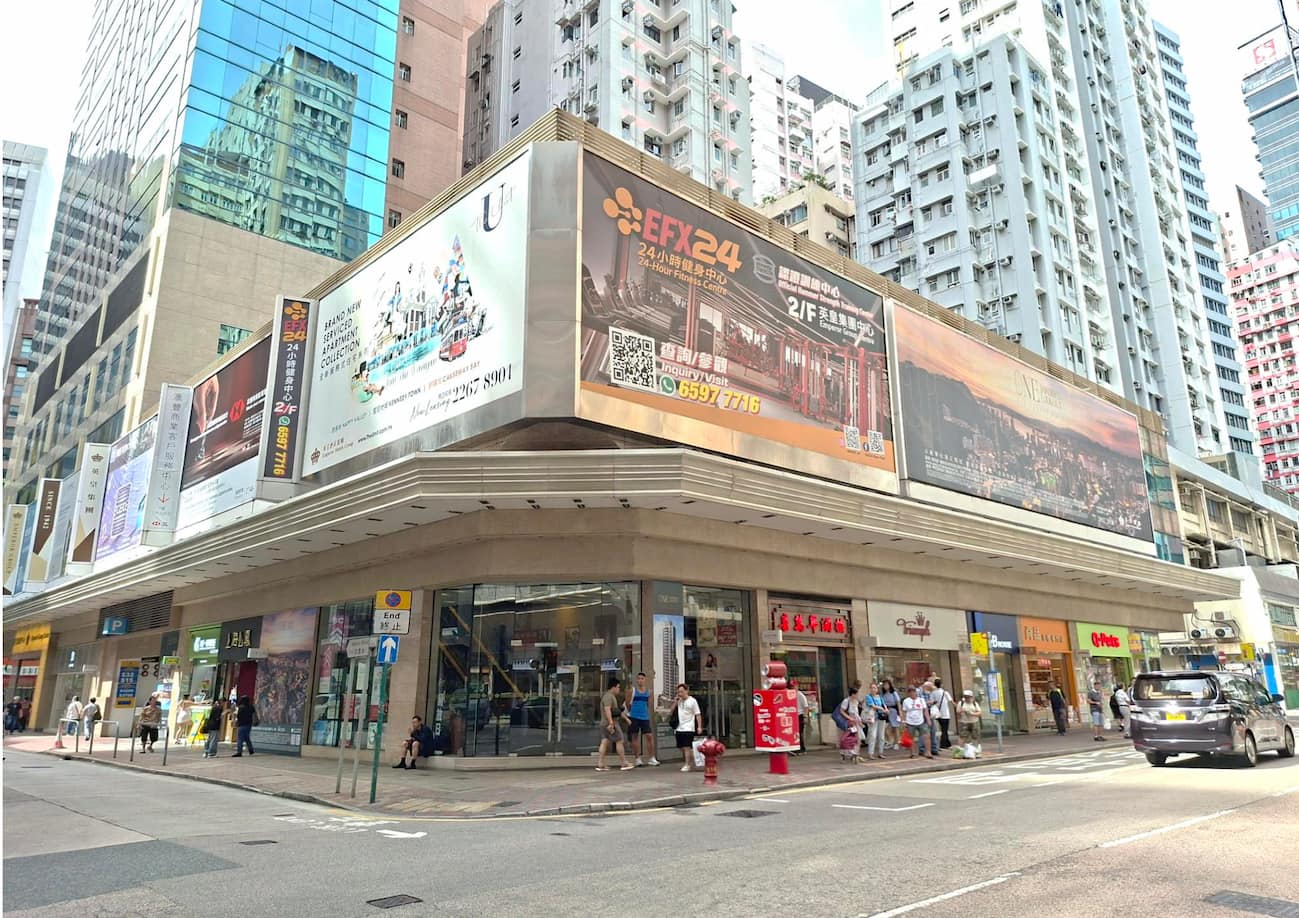 軒尼詩道街角，設有高樓大廈、地下舖位及上方廣告牌。