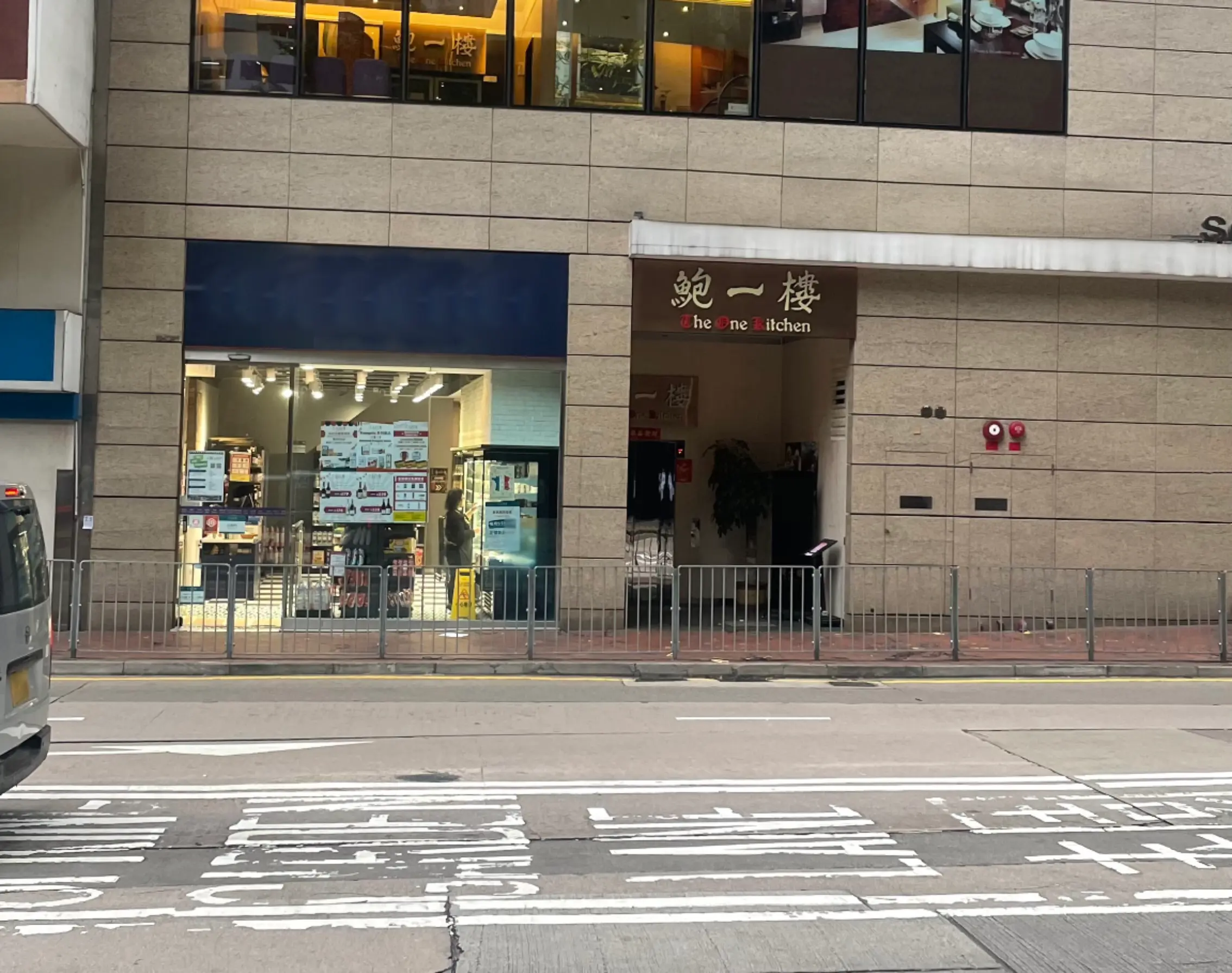 Street view of two shopfronts in a beige building—one convenience store, one "he ne kitchen" restaurant; both are available for rent as part of Ref#3652. Ideal if you're looking to rent shop or restaurant space.