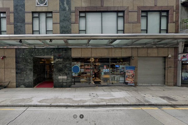 上環街景可見大型舖面櫥窗及行人道,鐵閘已關閉,左邊為建築物入口。
