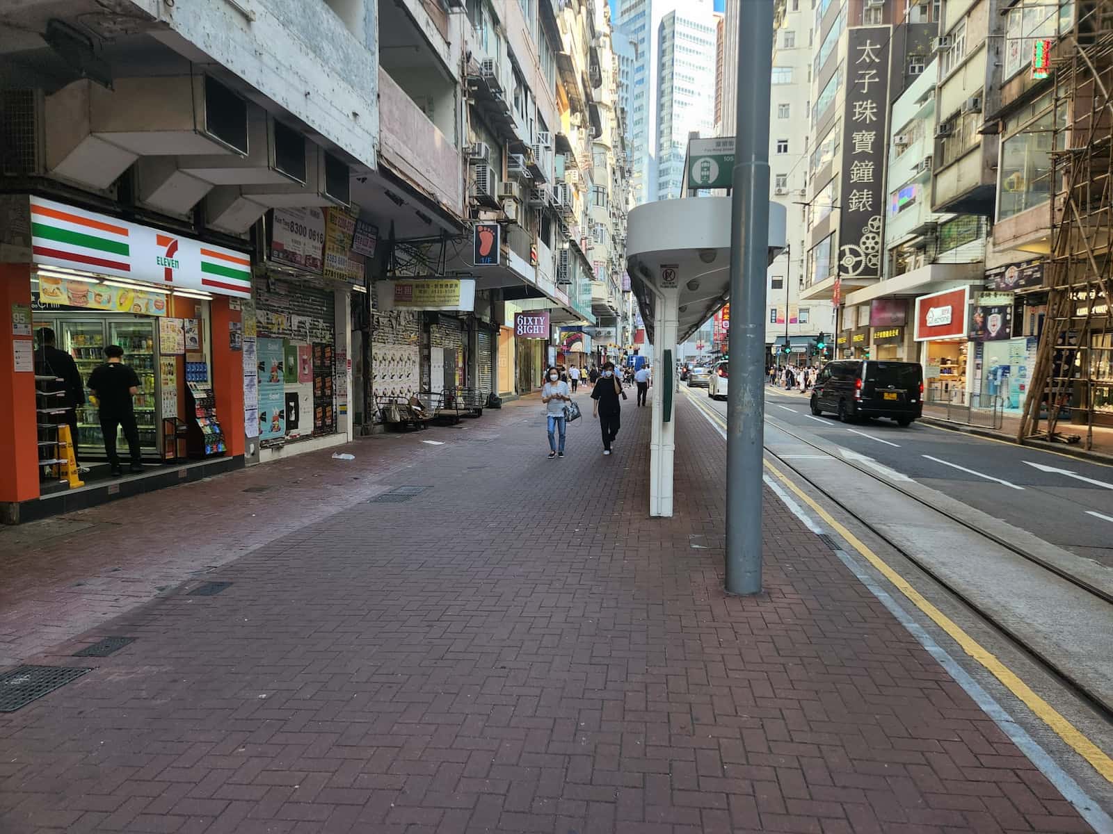 Ref#3578 depicts a city street with people on a brick sidewalk, shops (including 7-Eleven), tall buildings offering office and shop rentals, a black van driving by, and visible Chinese signage.