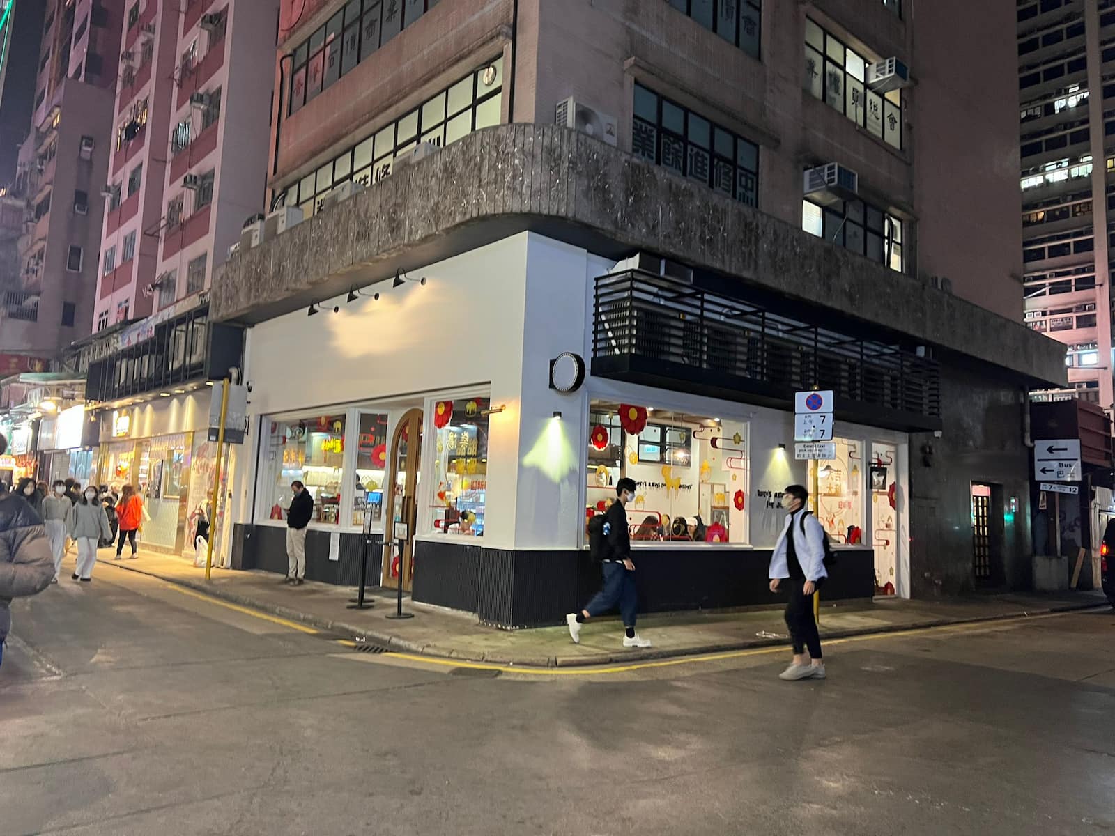 Ref#3258: Shop space for rent in a vibrant urban settingstreet corner location beneath tall apartments, with red lanterns, bright lighting, parked scooters, and active foot trafficideal for your next business.