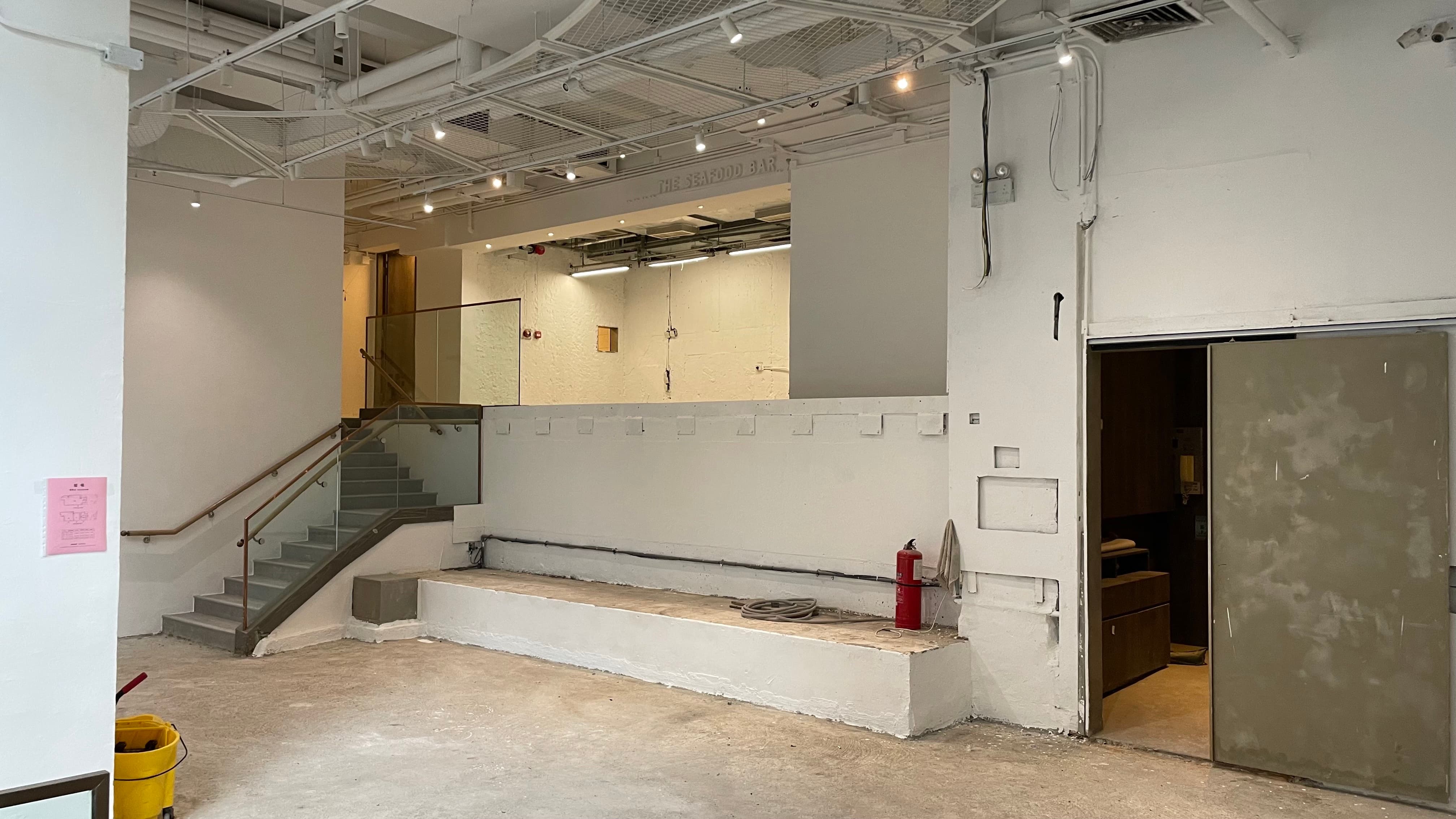 Ref#3494 is an empty, unfinished indoor space with white walls, concrete floors, a staircase on the left, wood cabinets on the right, and exposed ceiling pipes
d�perfect to rent as a shop or office.
