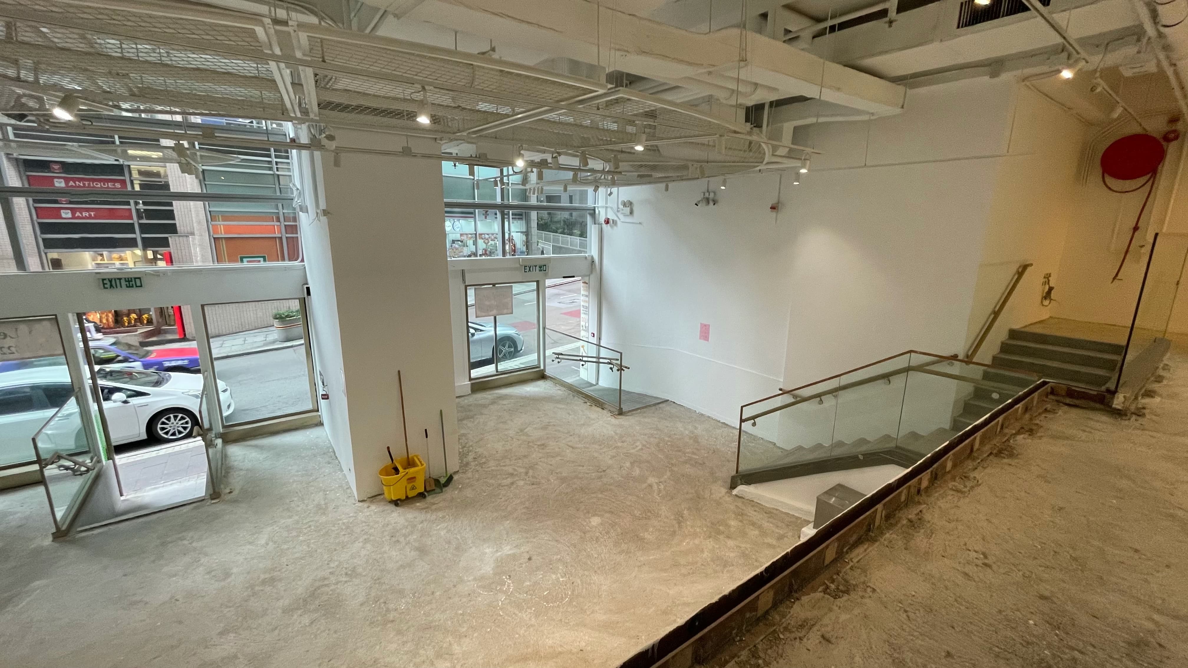 Ref#3494: Empty, unfinished commercial space with concrete floors, large windows, glass doors, glass-railed modern staircase, and street views
d�ideal for an office, restaurant, or shop.