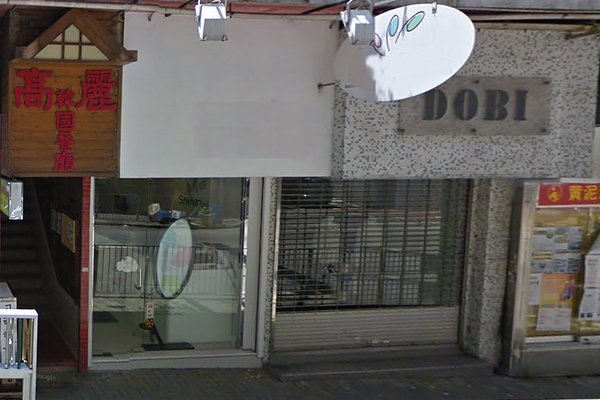 Ref#3452 features a shopfront with a closed metal shutter labeled DOBI beside a glass door, plus a wooden sign with Chinese characters and stairway entrance on the left. The area is peaceful and ideal for renting shop space.