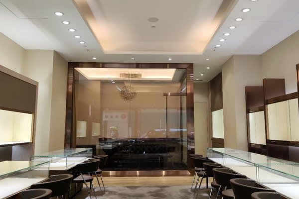 Ref#3225: Modern, well-lit jewelry store with glass display cases, dark chairs, beige walls, and a decorative ceiling light. Clean, minimalist design creates a welcoming atmosphereideal for shop rental.