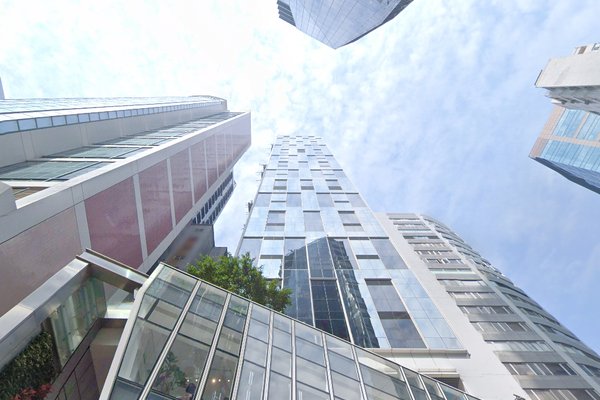Ref#3442 offers prime office rentals in tall, modern skyscrapers featuring glass and steel facades0an inspiring view beneath a blue, partly cloudy sky for your ideal urban workspace.