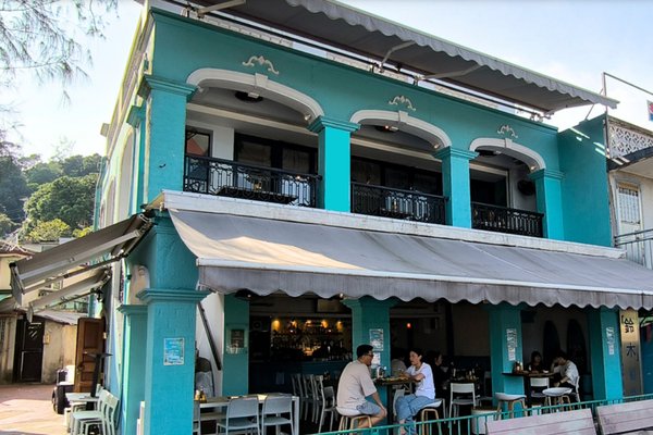 Ref#3593 is a turquoise two-story restaurant with arched windows and outdoor seating under a shaded awning—an ideal open-air space to rent for launching your new dining venture.
