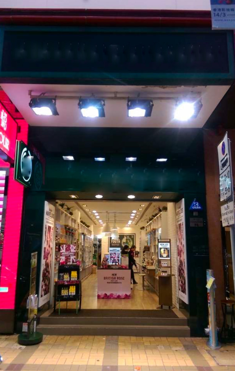 Ref#3331 is a brightly lit storefront for rent as a shop or office space, featuring large lights, an open entrance with wide doors, cosmetic displays inside, and a British Rose promo stand that enhances the welcoming vibe.