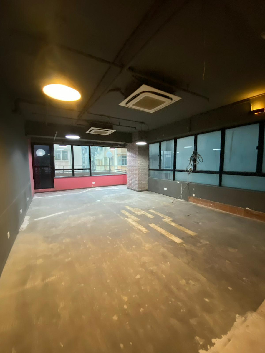 銅鑼灣渣甸街空置房間,混凝土地面外露,設天花燈、冷氣機及兩側大窗戶。
