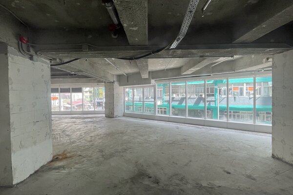 Ref#3292: Spacious unfinished room with concrete floors and exposed ceiling pipesideal for shop rental. Large windows on two walls provide city and street views.