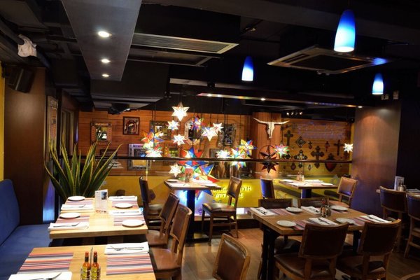 Ref#3547 features a cozy restaurant interior with wooden tables and chairs, star-shaped hanging lights, blue pendant lamps, wall art, and neatly set tablesideal for restaurant rental or an inviting dining space.