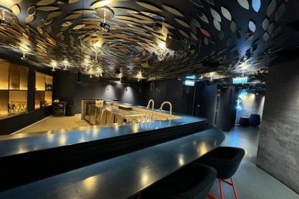 Ref#3347 features a modern bar with a sleek black counter, high stools, ambient yellow lighting, and metallic leaf-shaped décor—perfect for those seeking to rent contemporary restaurant space.