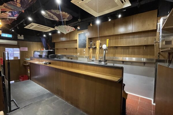 Ref#3523: Spacious, clean bar for rent featuring wooden shelves, a counter, beer taps, and ceiling lights. The shelves are empty and the space is unoccupied—ideal for anyone looking to lease restaurant space.