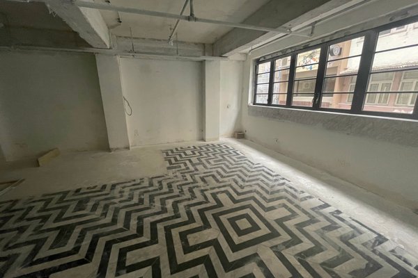 Ref#3341: Unfinished room with bare concrete walls, ceiling, large windows for ample natural light, and a black-and-white zigzag tile floor	64perfect to rent as a shop or office.