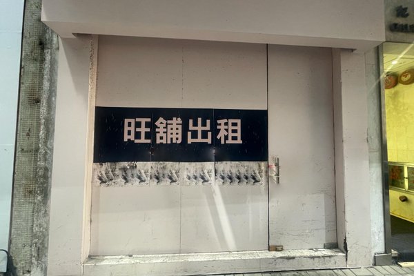 A closed storefront with a large black sign displaying Chinese characters for "prime shop for rent" (Ref#3250). The area around the door and sign appears worn and slightly weathered, ideal for shop rental.