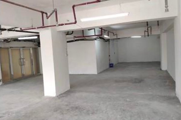 Ref#3364 offers a spacious, unfinished room with concrete floors, white walls, exposed ceiling pipes, and fluorescent lighting. Glass double doors on the left add a modern industrial touchideal for office or shop rental.