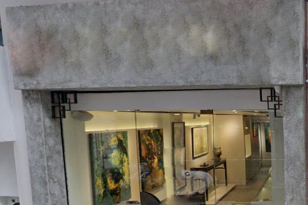 Ref#3555 is a modern art gallery with a large glass window displaying interior paintings. Its neutral gray exterior and minimalist design make it perfect to rent as an office or shop.