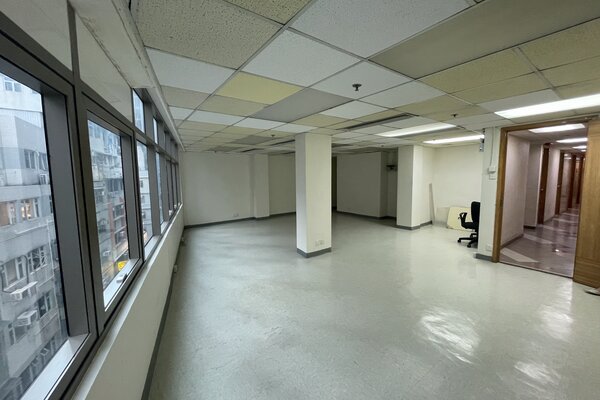 Ref#3204: Spacious office with white walls, tiled ceiling, and large windows for ample lightideal for office rental. Features a modern light gray reflective floor, single chair by the hallway, and access to several closed rooms.