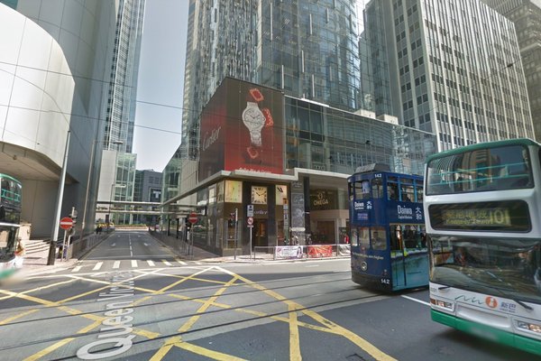 A bustling city intersection with trams, buses, tall glass buildings, and an Omega ad. Ref#3298 offers ideal retail or office spaces to rent at these vibrant corners marked by yellow crosshatch lines.