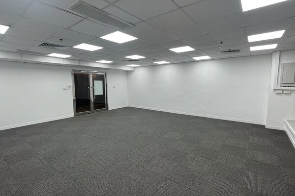 Ref#3562: Office space featuring gray carpet, white walls, a drop ceiling with bright fluorescent lighting, and double glass doors at the far end

perfect for office or shop rental.