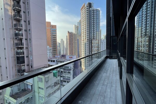 Ref#3176 features a modern balcony with glass railing, offering views of tall apartment buildings—perfect for renting office or shop space in a lively urban setting under blue skies.