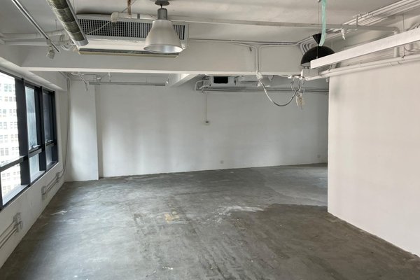 Ref#3326 is an empty commercial space with bare concrete floors, white walls, exposed ceiling pipes, large windows on the left, and hanging light fixturesideal for a restaurant or shop rental.