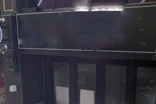 Ref#3580: Dark storefront featuring a blank black sign above double glass doors. This vacant space has minimal lighting, no visible branding or decorations0ideal for renting a shop or opening a new restaurant.
