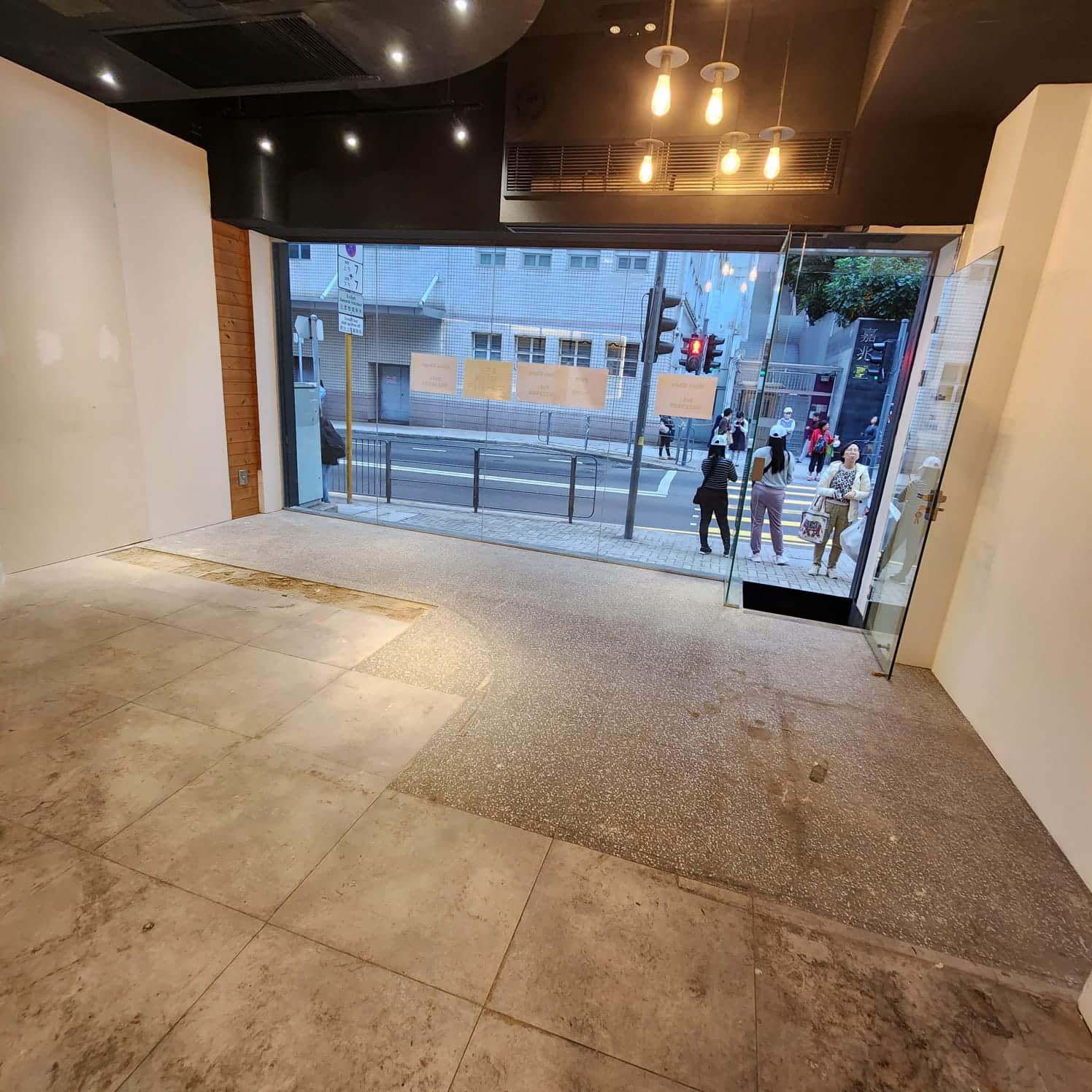 Ref#3008: Bright retail space with tiled speckled floors, large front windows, and a glass door opening to a busy city street. Perfect to rent for a shop or office 6excellent visibility with ceiling lights as people walk by.