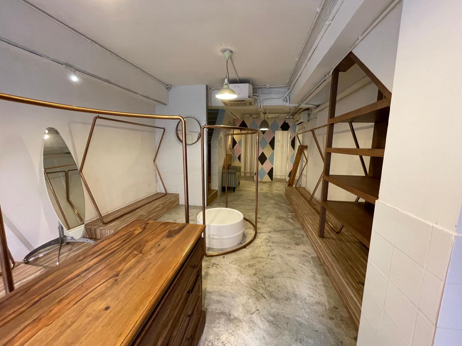 Ref#2991 offers a modern space perfect for office or shop rental, with wooden shelves, railings, polished concrete floors, a white round bathtub centerpiece, geometric pastel wall art, and bright ceiling lighting.