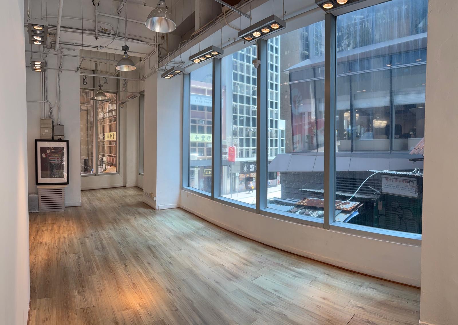 Ref#3233 is a bright, modern gallery space with large floor-to-ceiling windows, wood floors, white walls, a framed picture, and city views—ideal to rent as an office or shop.