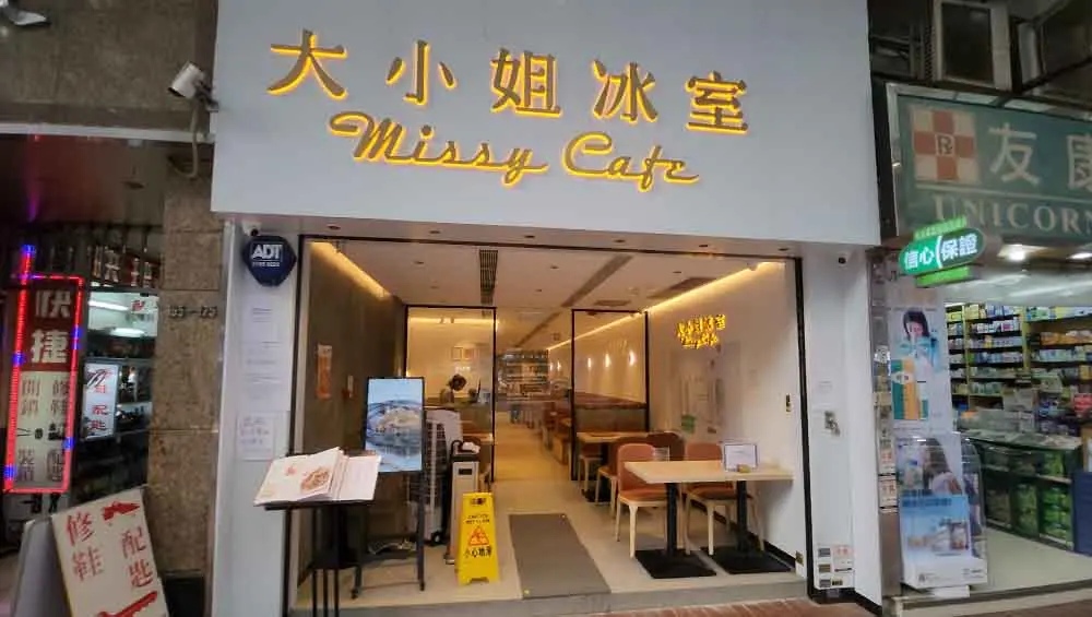 Restaurant space on King's Road, North Point. Missy Cafe storefront on King’s Road with yellow signage open entrance seating and a wet floor sign inside.