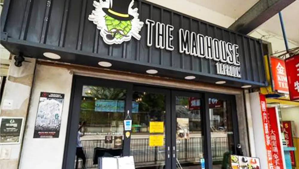 Restaurant space on Yim Po Fong Street, Mong Kok. Entrance of The Madhouse Taproom Mong Kok with glass doors and signs at the doorway.