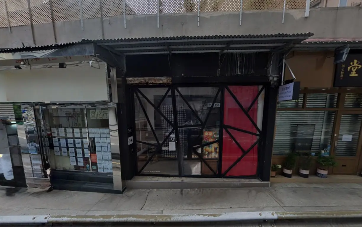 Shop on Caine Road, Mid-Levels. Small storefront with glass door and black frame, beside potted plants on the sidewalk.
