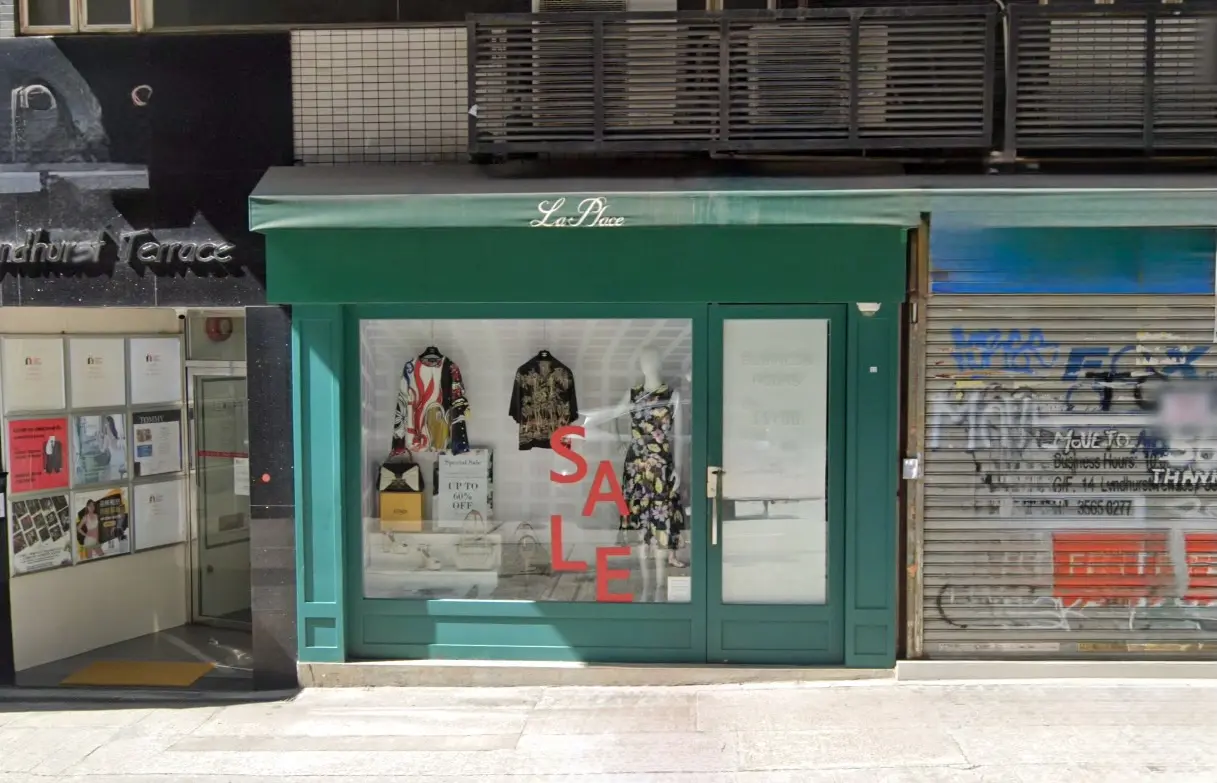 Shop on Lyndhurst Terrace, Central. Green storefront with glass windows Central shows red letters and shop name La Place.