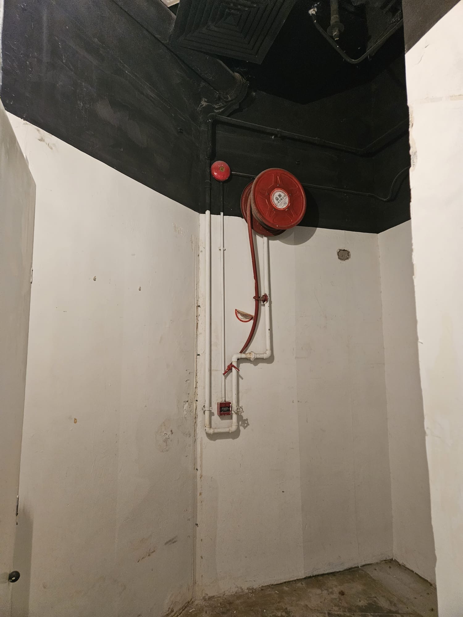 Small room with white walls, black ceiling, and a red fire hose reel on Lyndhurst Terrace in Central.